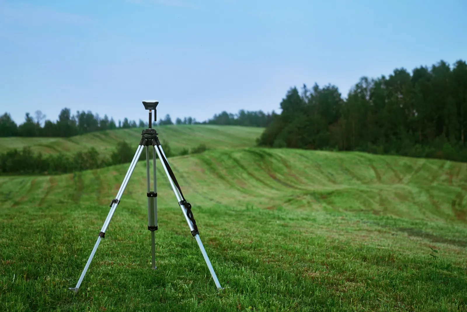 Surveying instrument on a tripod set up on a lot before a cottage is built in Quebec