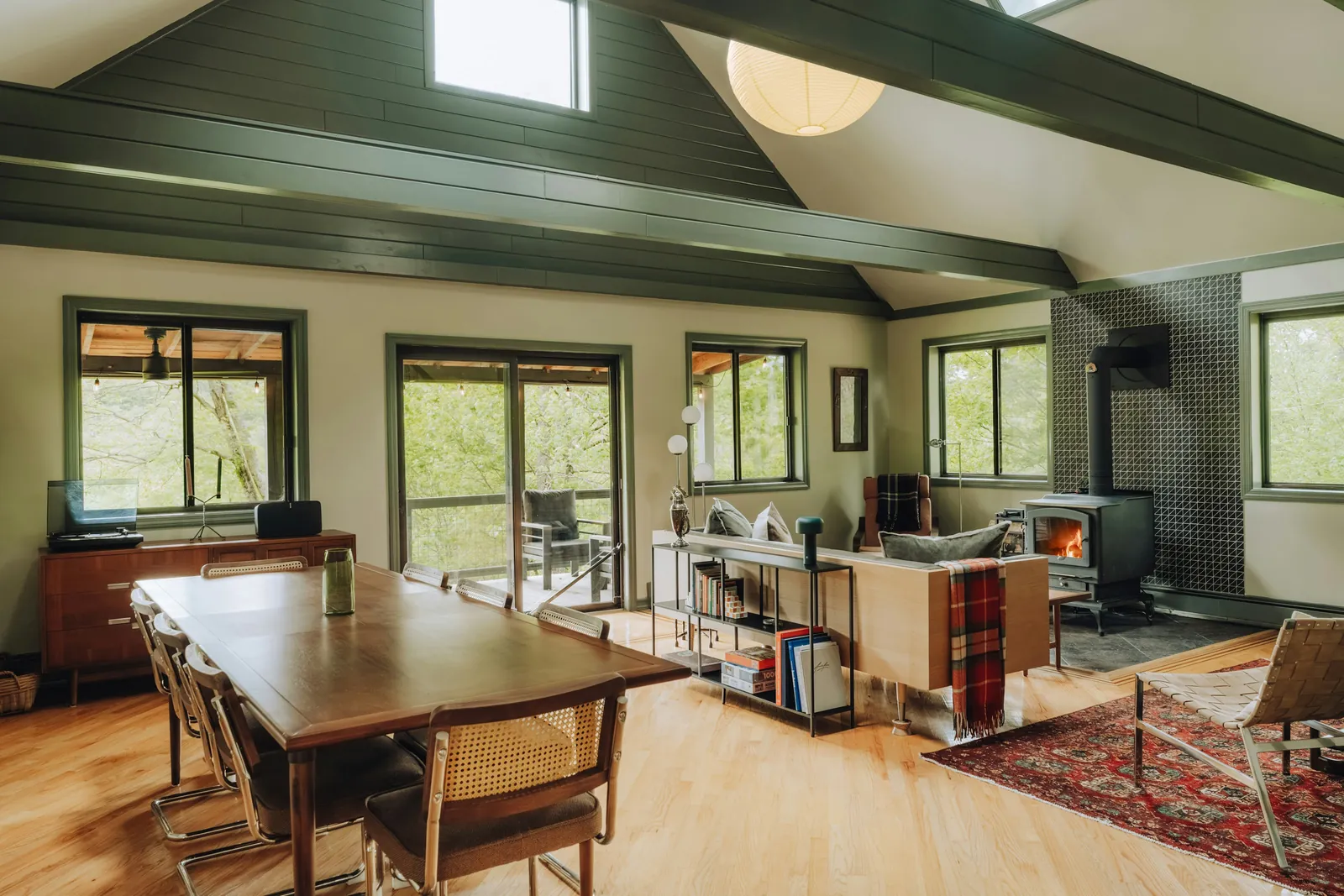 Aire ouverte d'un chalet avec plafond voûté en bois et poêle à bois, un intérieur chaleureux et durable