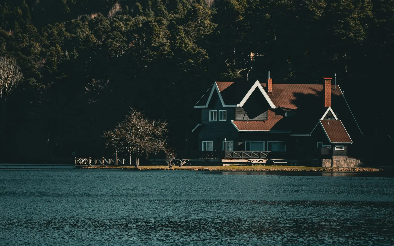Chalet de luxe au bord d'un lac, adossé à une montagne boisée dans un secteur de villégiature au Québec