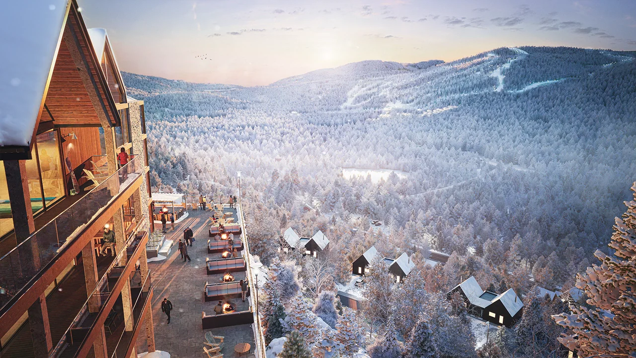 Terrace of a large cottage at sunset overlooking a snow-covered valley and ski runs