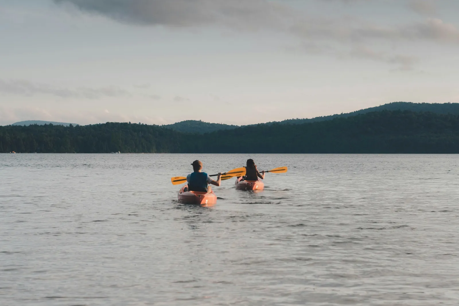 Couple kayaking on a calm lake, a highlight of life at a waterfront cottage