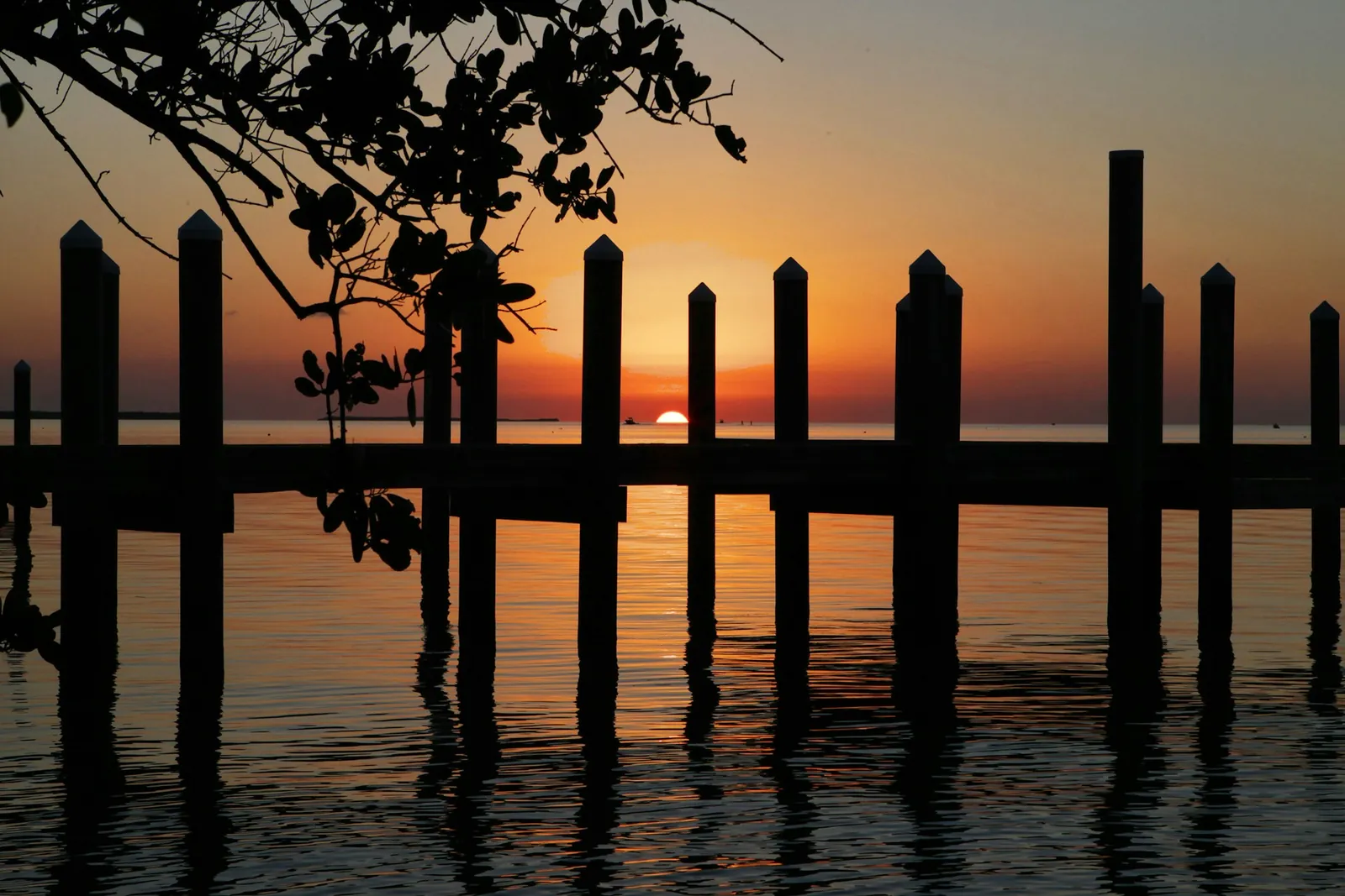 Quai en bois au coucher du soleil devant un plan d'eau, près d'un chalet locatif au Québec