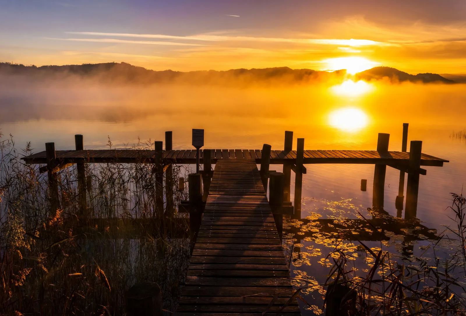 Wooden dock at sunset on a lake, a sought-after feature of a waterfront property
