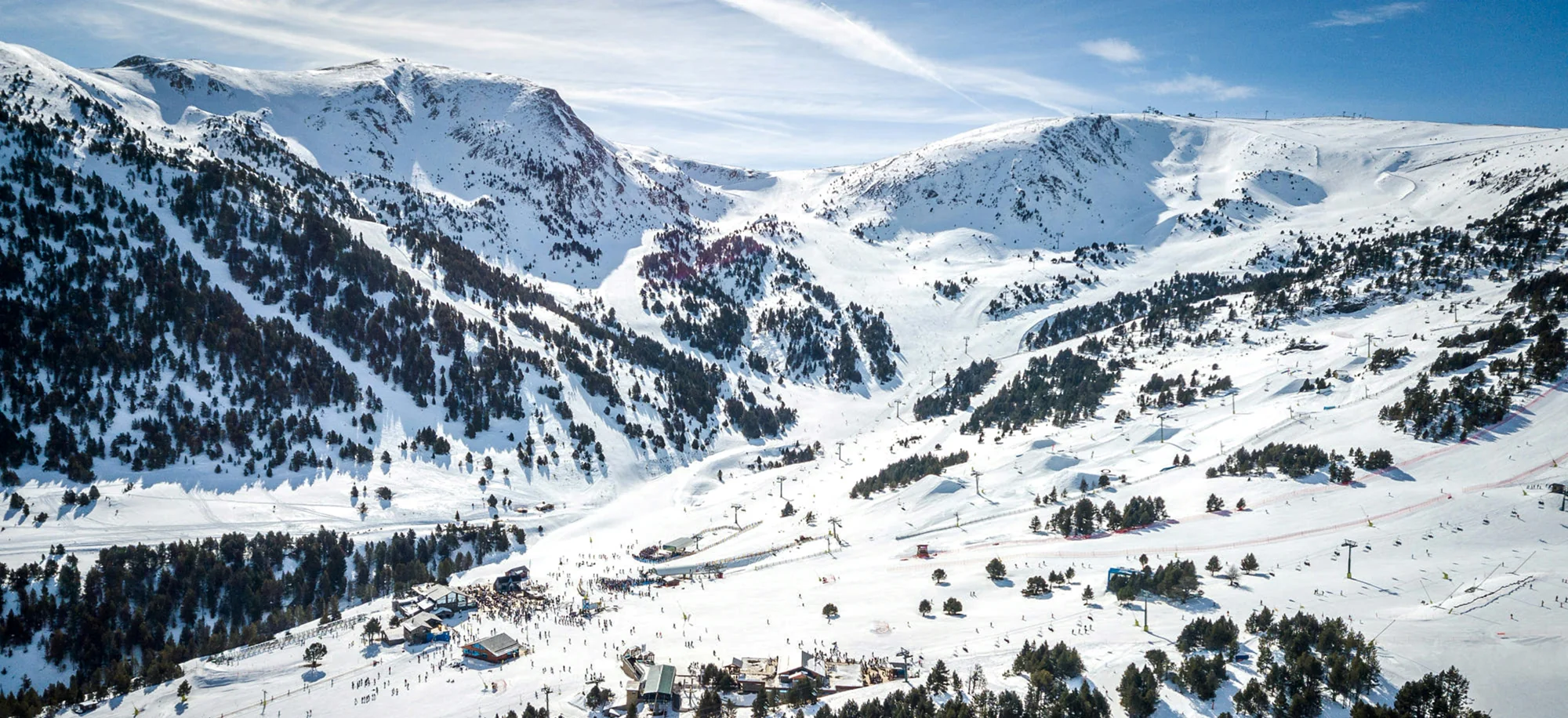 Aerial view of a mountain ski resort with snow-covered runs and chairlifts