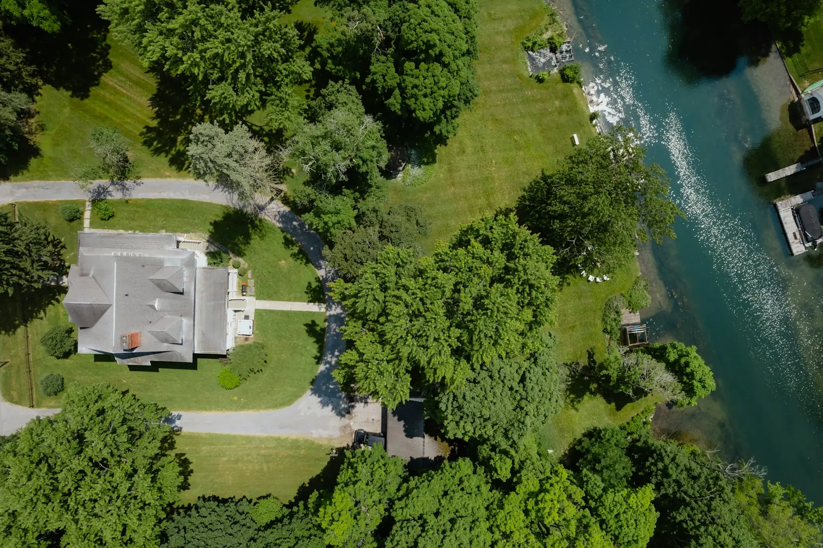 Aerial view of a wooded lot on the shore of a lake in the Laurentians